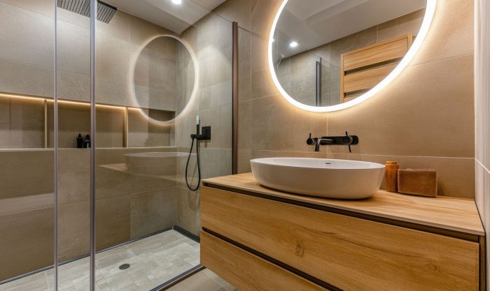 Modernes Bad mit Holzoptik-Dusche und beleuchtetem Rundspiegel
