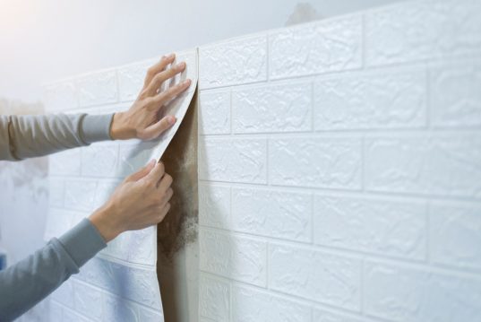 Worker hands sticking wallpaper on wall, Home decoration by your