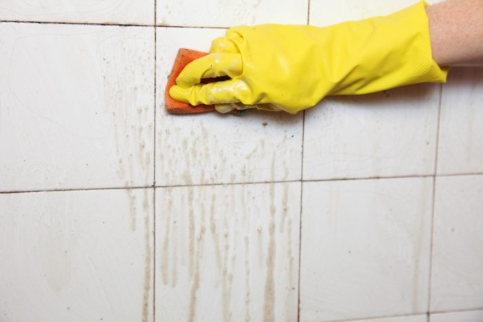 Fliesenreinigung von Hand mit Schwamm