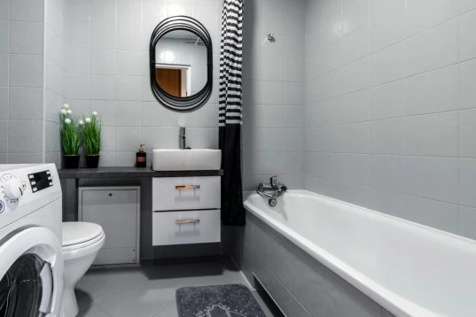 Kompakte Badewanne an der Wand im kleinen Bad