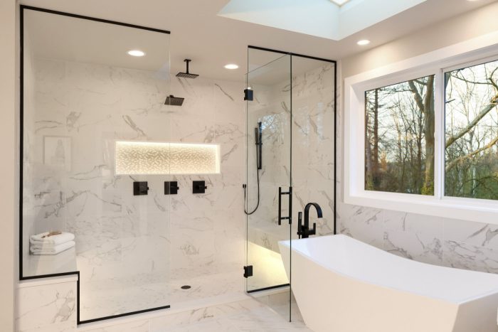 Walk-in-Dusche in Marmor-Mosaik mit Messing-Armaturen und freistehender Wanne
