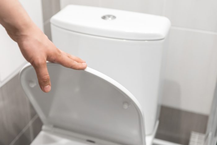Toiletten-Arten: Die besten WC-Modelle für mehr Komfort 11 Person schliesst Toilettendeckel