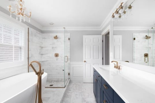 Weisses Luxusbadezimmer mit Kronleuchter und blauem Waschtisch